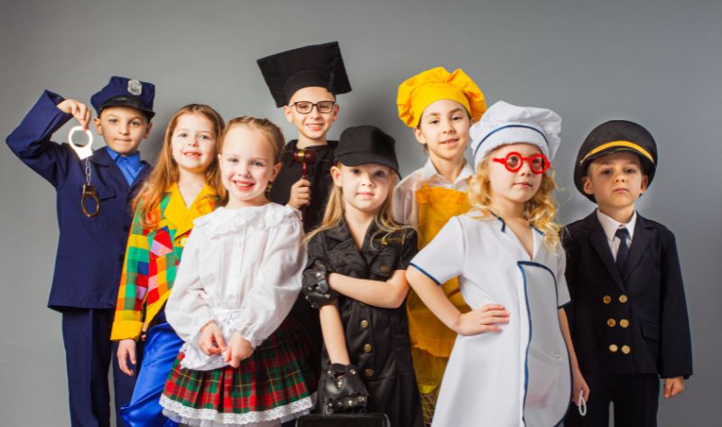 Kids in different costumes like police officer, chef, pilot, and doctor – perfect inspiration for a themed scavenger hunt. Ideal for a creative treasure hunt where characters and role-play bring the adventure to life.