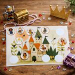 Princess and knight scavenger hunt game board with castle illustration, character tokens, path arrows, and decorative gems arranged on a wooden background